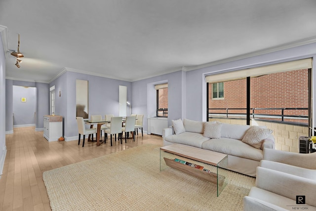 living room with baseboards, ornamental molding, and wood finished floors