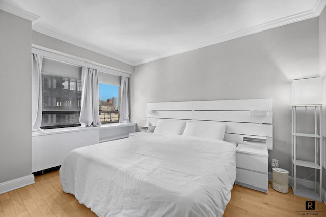 bedroom featuring baseboards, ornamental molding, and light wood-type flooring