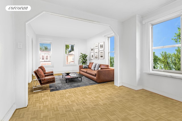 living room featuring baseboards, arched walkways, and visible vents