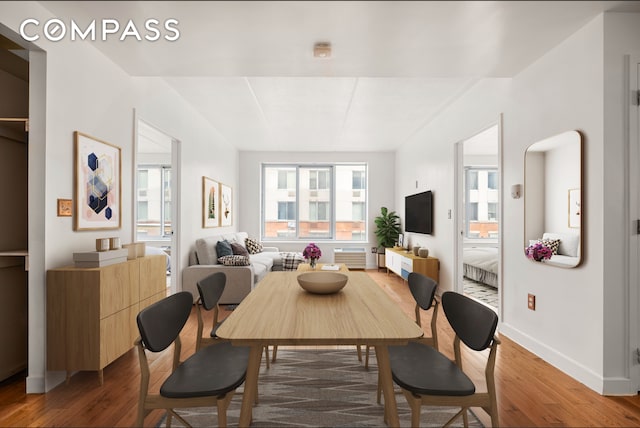 dining space with wood-type flooring and baseboards