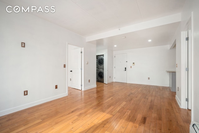 29 W 138th St Unit 2D, New York City, NY 10037 - unfurnished room with stacked washing machine and dryer, light wood finished floors, a baseboard radiator, and recessed lighting