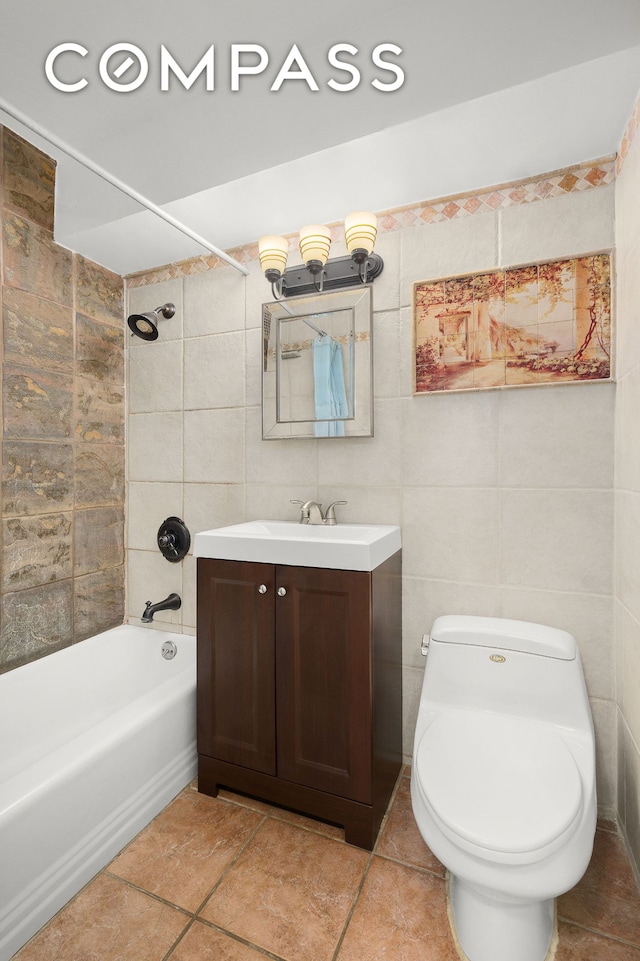 full bath featuring toilet, tile walls, shower / washtub combination, and vanity