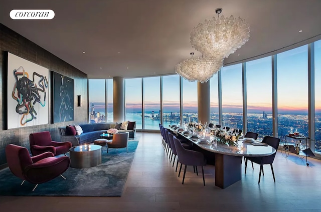 dining area featuring an inviting chandelier, a water view, visible vents, a wall of windows, and wood finished floors