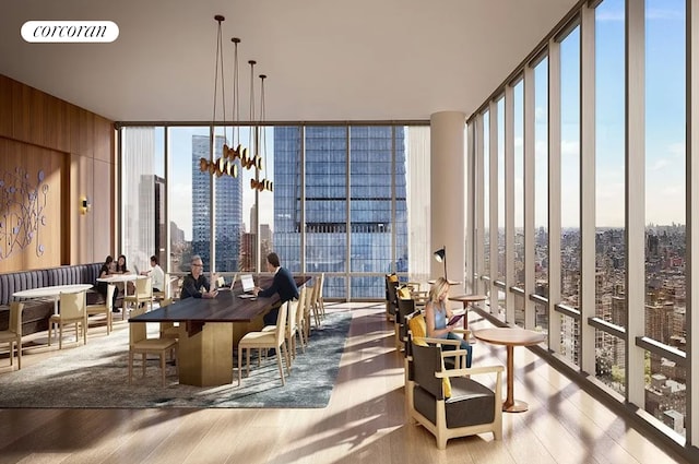 interior space featuring a view of city, visible vents, a wall of windows, and wood finished floors