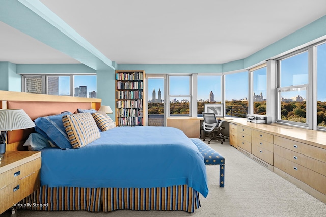 bedroom featuring light carpet and a city view