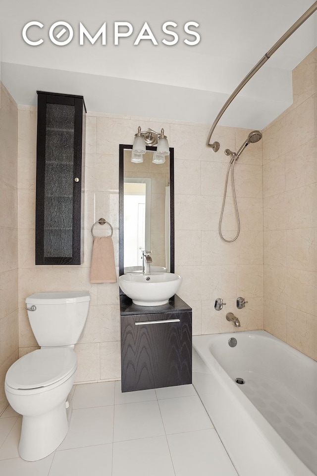 bathroom featuring toilet, shower / bathing tub combination, tile patterned flooring, and tile walls