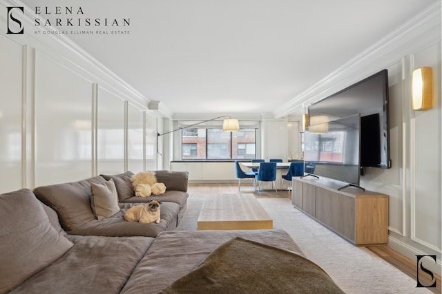 living area featuring ornamental molding and light wood finished floors