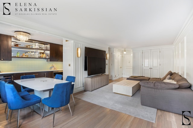 living area featuring light wood-style flooring and ornamental molding