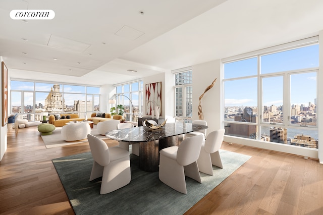 dining room featuring a view of city, visible vents, and a wall of windows