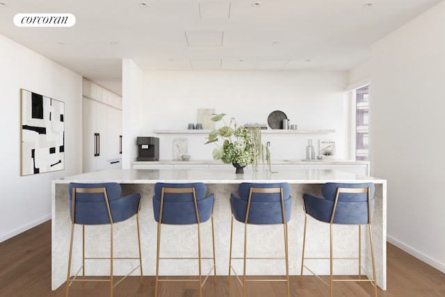 kitchen with a breakfast bar area, visible vents, open shelves, and wood finished floors