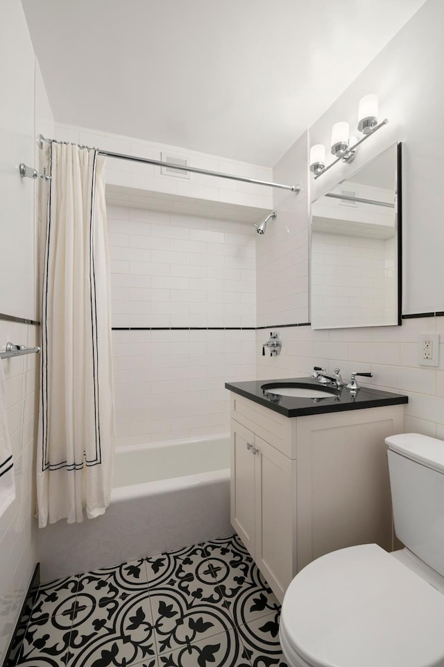 full bath with tile patterned flooring, toilet, vanity, tile walls, and shower / bathtub combination with curtain