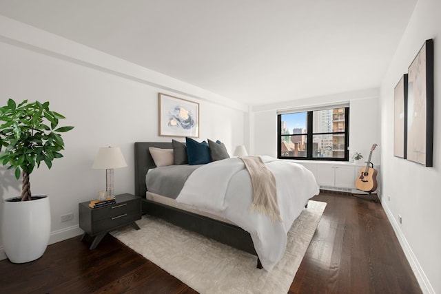 bedroom with dark wood-style floors and baseboards