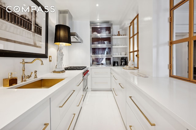 kitchen featuring light countertops, open shelves, white cabinets, modern cabinets, and a sink