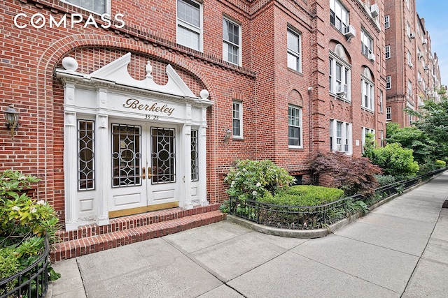 entrance to property featuring french doors and brick siding