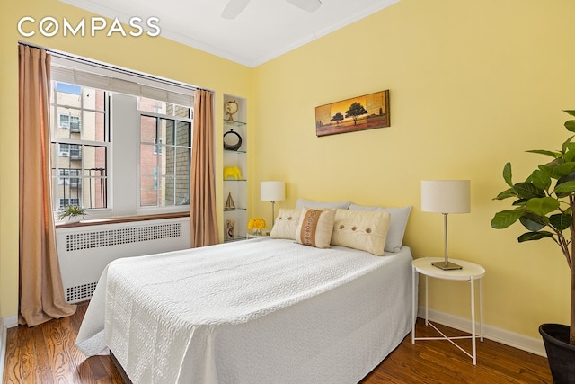 bedroom featuring crown molding, radiator, a ceiling fan, wood finished floors, and baseboards