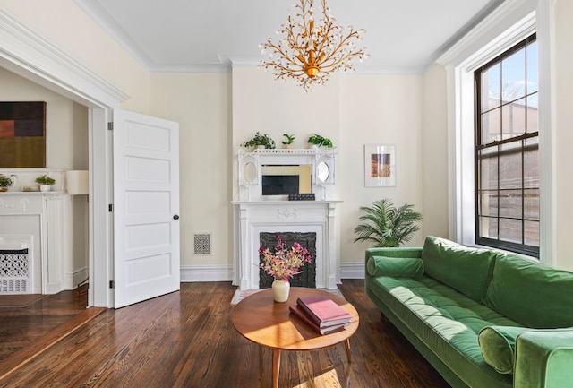 living room with visible vents, wood finished floors, a fireplace, and crown molding