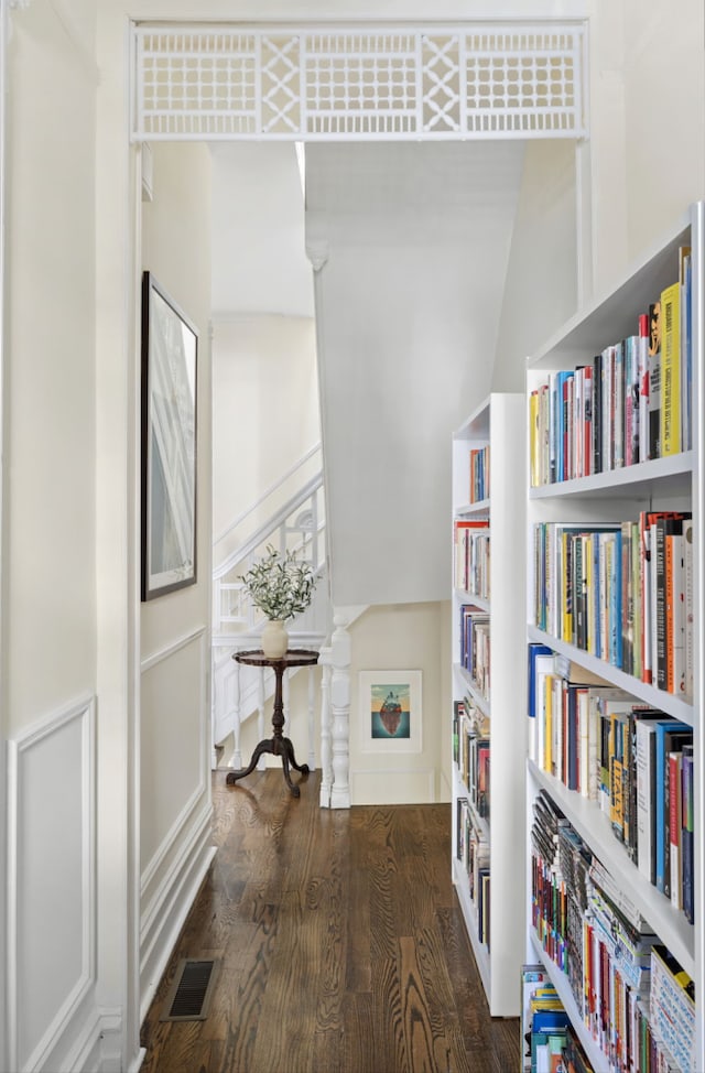 hall featuring wood finished floors and visible vents