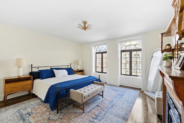 bedroom with wood finished floors and a fireplace