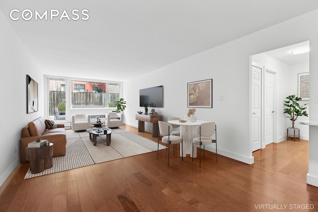 living area with baseboards and wood finished floors