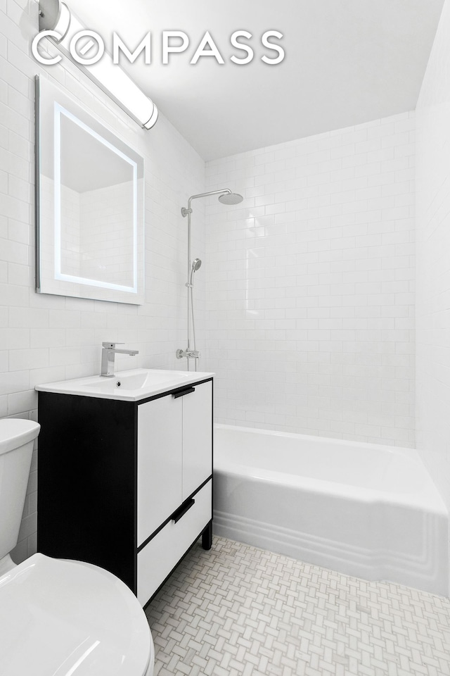 bathroom with toilet, shower / bath combination, tile walls, and vanity