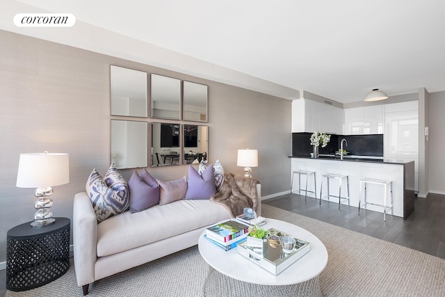 living area with dark wood-style floors, visible vents, and baseboards