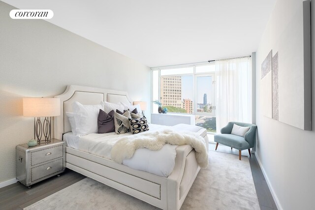 385 1st Ave Unit 8F, New York City, NY 10010 - bedroom featuring baseboards, wood finished floors, and a city view