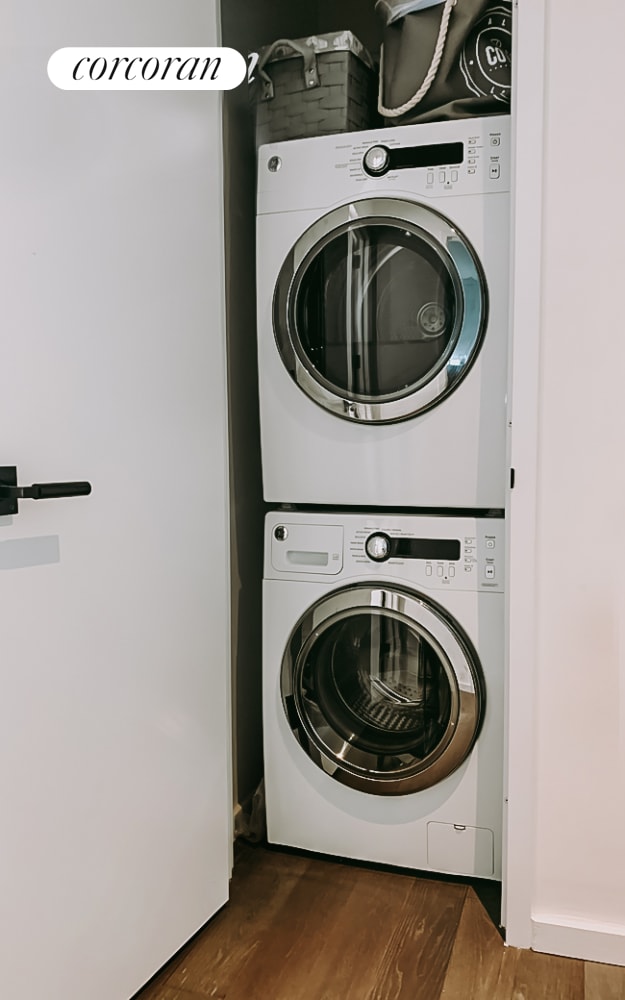 laundry room with stacked washer and dryer, laundry area, and wood finished floors