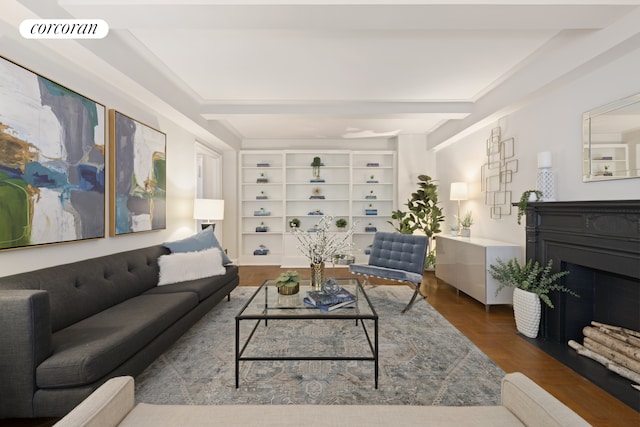 living room featuring beam ceiling, a fireplace, and visible vents