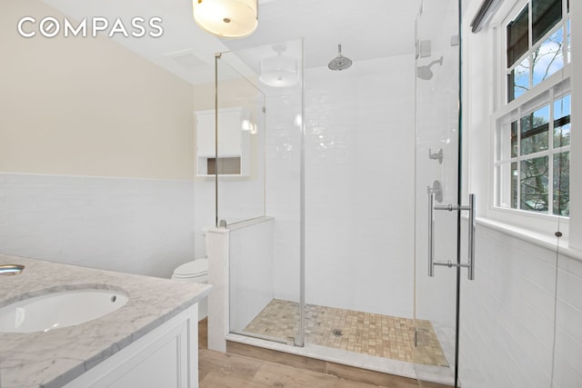 bathroom featuring tile walls and a shower stall