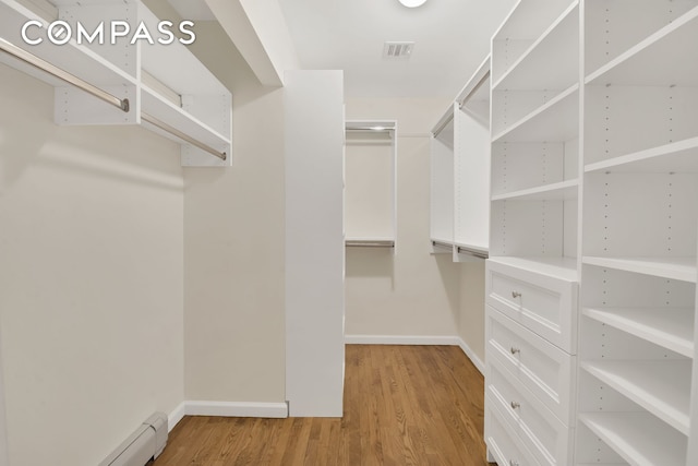 walk in closet featuring baseboard heating, visible vents, and light wood-style floors