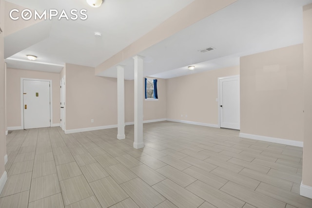 below grade area featuring baseboards, visible vents, and wood finish floors