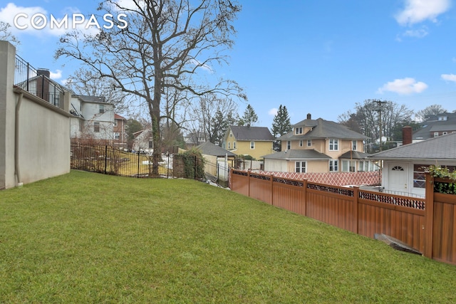 view of yard with a fenced backyard and a residential view