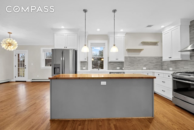 kitchen featuring a baseboard radiator, butcher block counters, visible vents, and appliances with stainless steel finishes