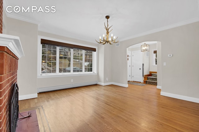 unfurnished living room with wood finished floors, arched walkways, an inviting chandelier, a fireplace, and baseboard heating