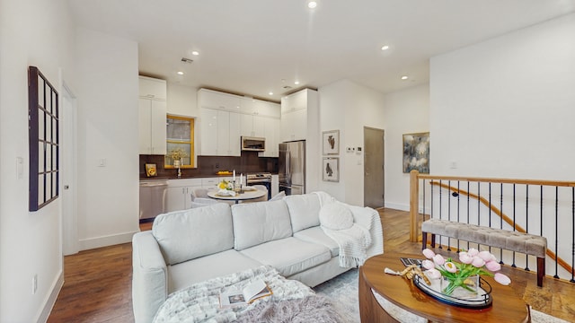 living room featuring visible vents, recessed lighting, baseboards, and wood finished floors