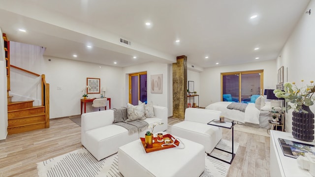 living area featuring recessed lighting, visible vents, light wood-style flooring, and stairs