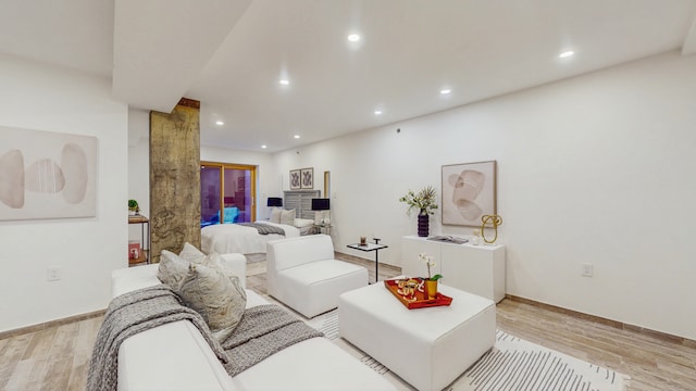 living room with recessed lighting, light wood-style flooring, and baseboards