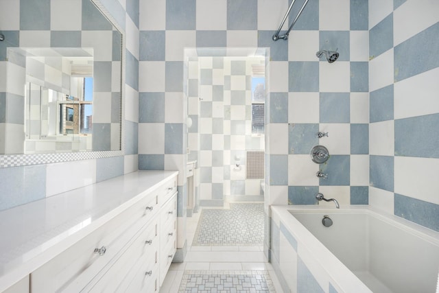 bathroom featuring tiled tub, vanity, a tile shower, and tile patterned floors