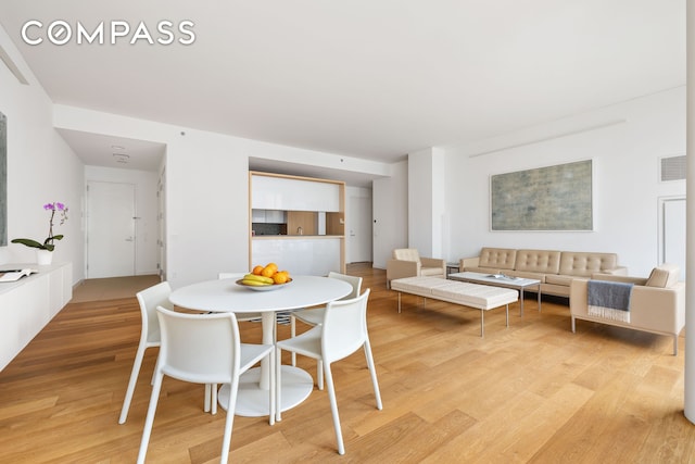 dining room featuring light wood-type flooring and visible vents