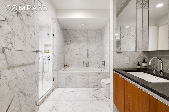 bathroom with a marble finish shower, a garden tub, marble finish floor, vanity, and tile walls