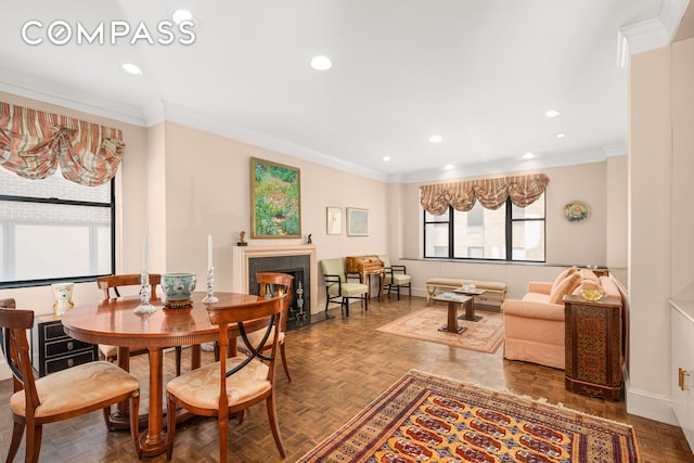 dining room featuring recessed lighting, crown molding, baseboards, and a premium fireplace