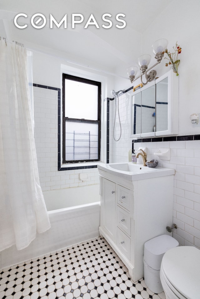 1680 Ocean Ave Unit 6D, New York City, NY 11230 - bathroom featuring tile walls, shower / bathtub combination with curtain, tile patterned flooring, vanity, and toilet