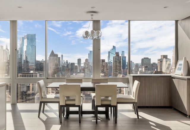 sunroom / solarium featuring an inviting chandelier and a city view