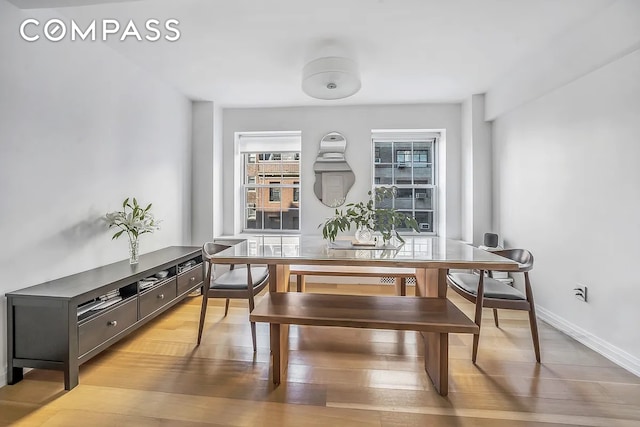 dining area with light wood-type flooring and baseboards