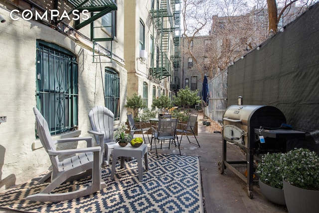 view of patio featuring outdoor dining space, fence, and grilling area