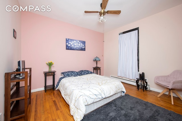 bedroom with wood finished floors, baseboards, a baseboard radiator, and ceiling fan
