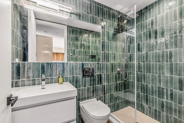 full bath featuring toilet, tiled shower, vanity, and tile walls