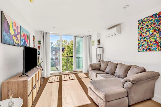 living area with light wood finished floors and a wall unit AC