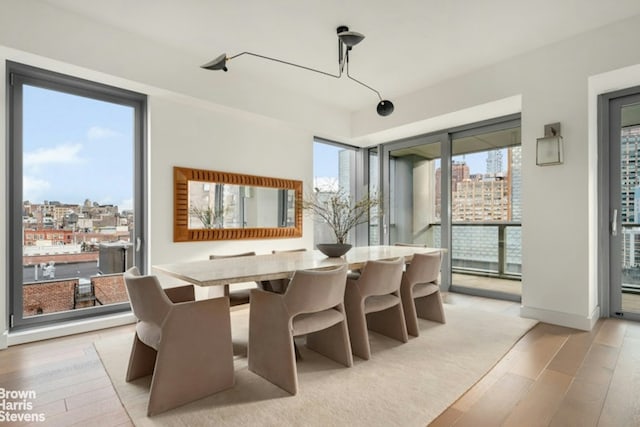 dining room featuring a view of city and light wood-style flooring