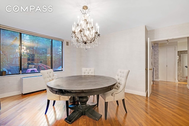 309 E 49th St Unit 2B3B, New York City, NY 10017 - dining space featuring light wood-style flooring, a chandelier, and radiator